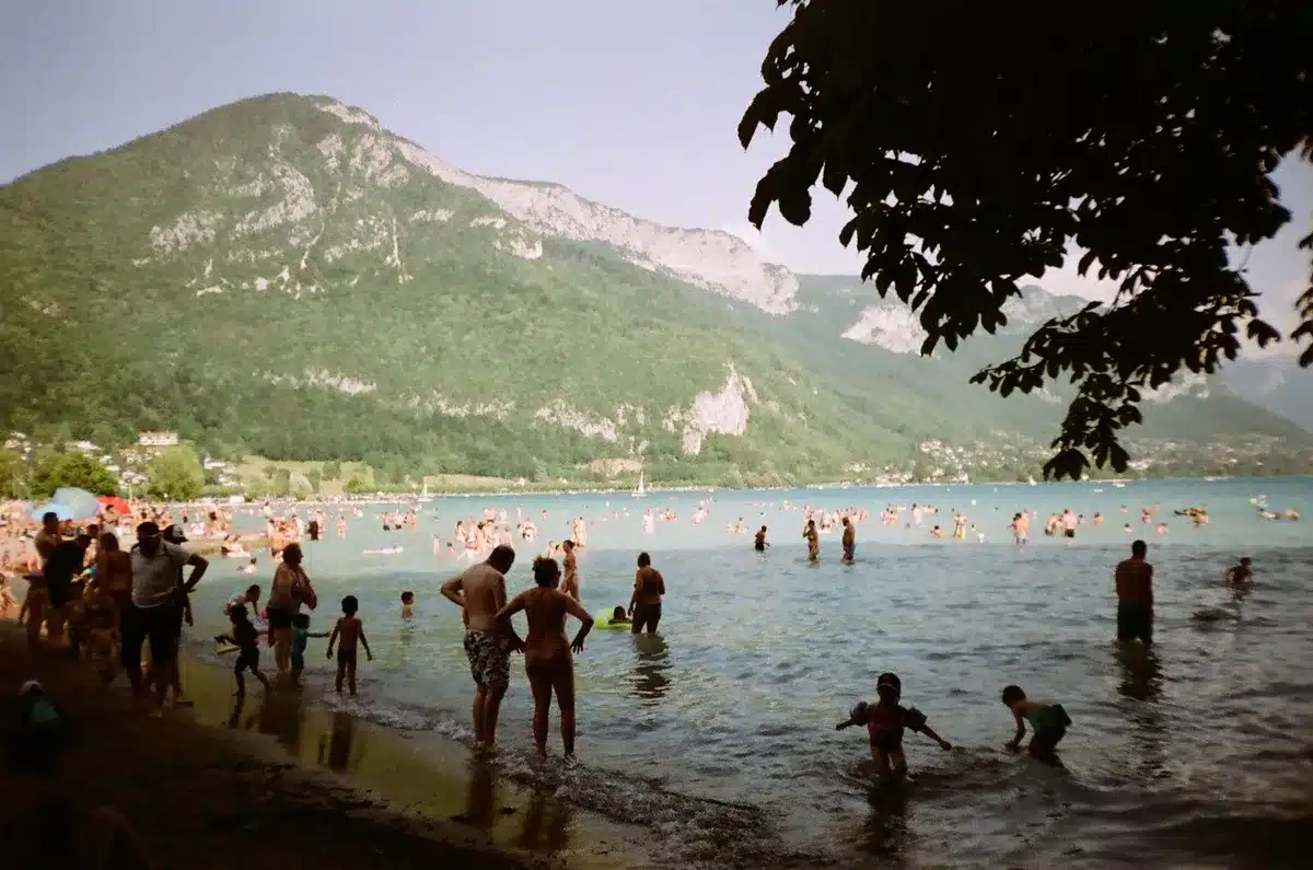Tłoczna plaża nad jeziorem w sezonie letnim z kąpiącymi się turystami