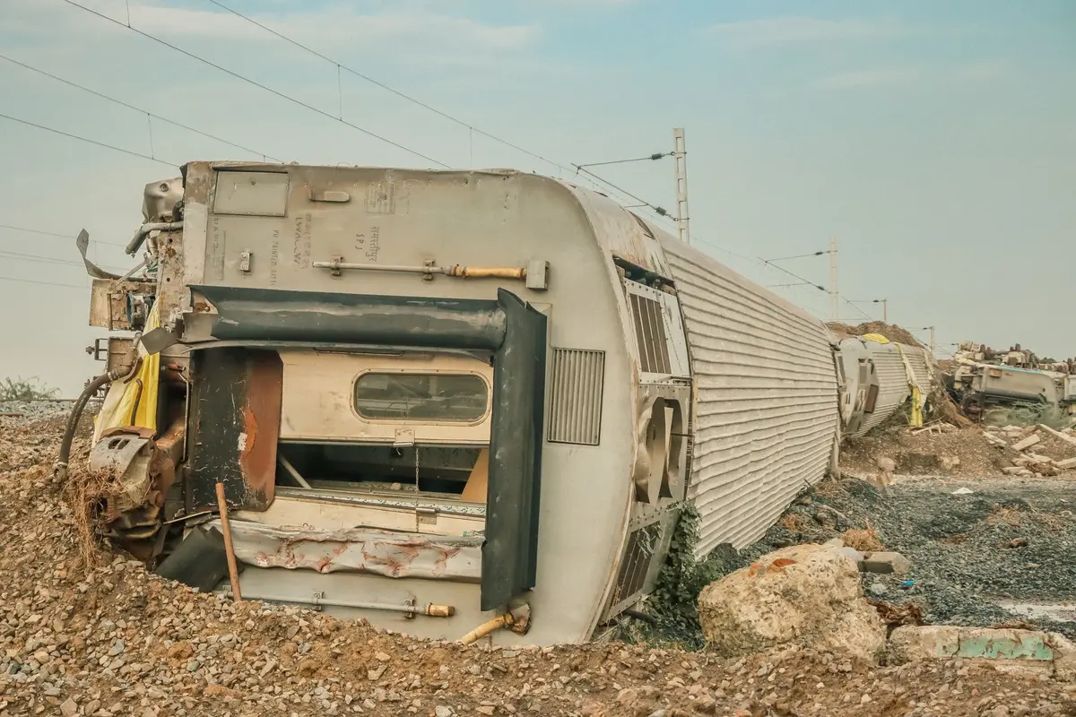 Przewrócony autobus z uszkodzeniami karoserii na miejscu wypadku