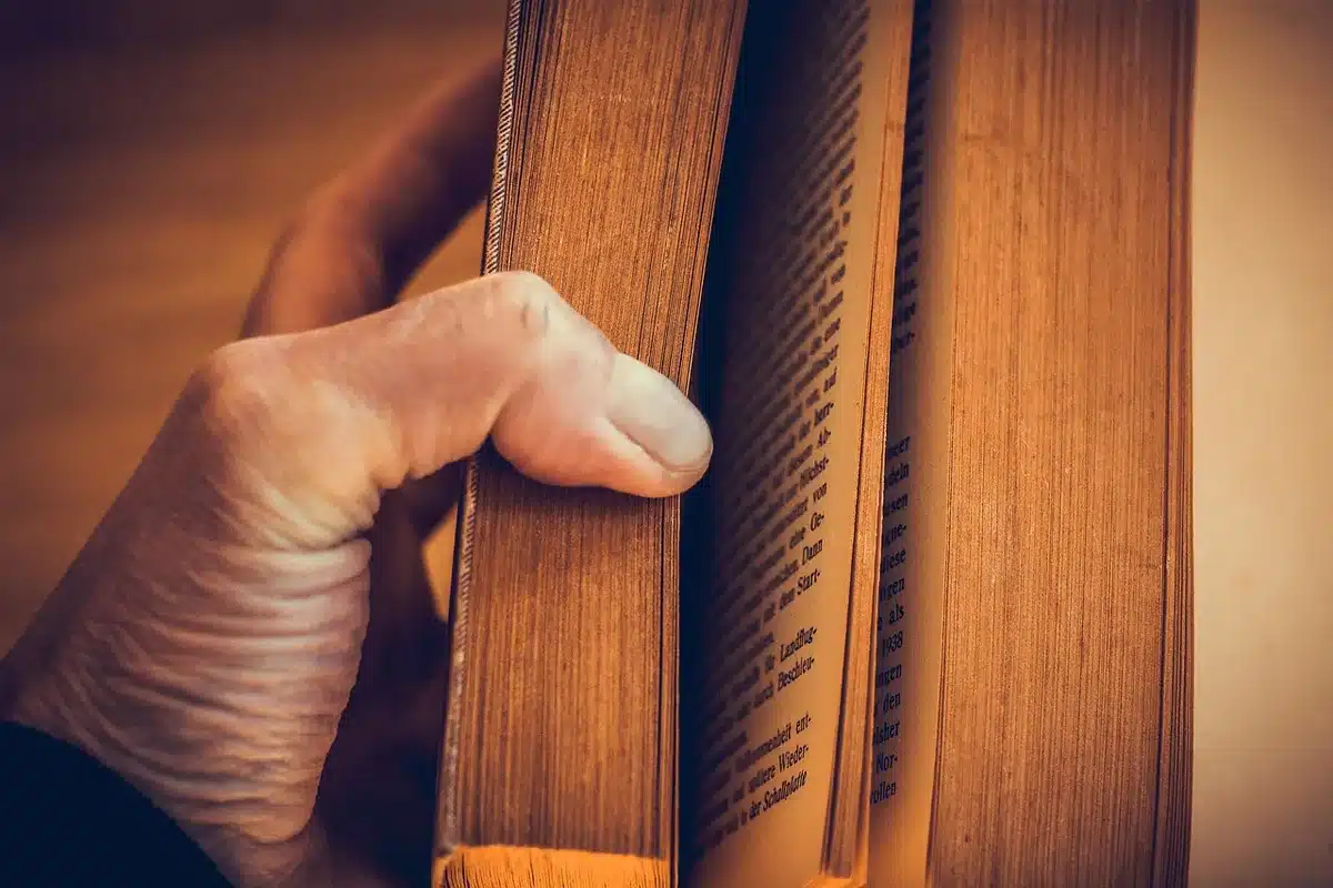 Otwarta książka wspomnień na stole z rękopisem obok