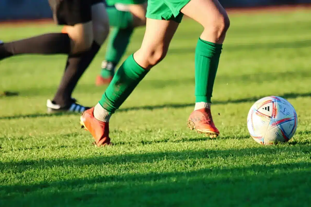 Dwaj piłkarze walczą o piłkę na boisku podczas meczu w świetle stadionowych reflektorów