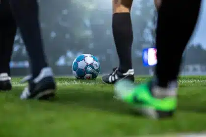 Anonimowe sylwetki piłkarzy przy linii pola karnego na stadionie nocą