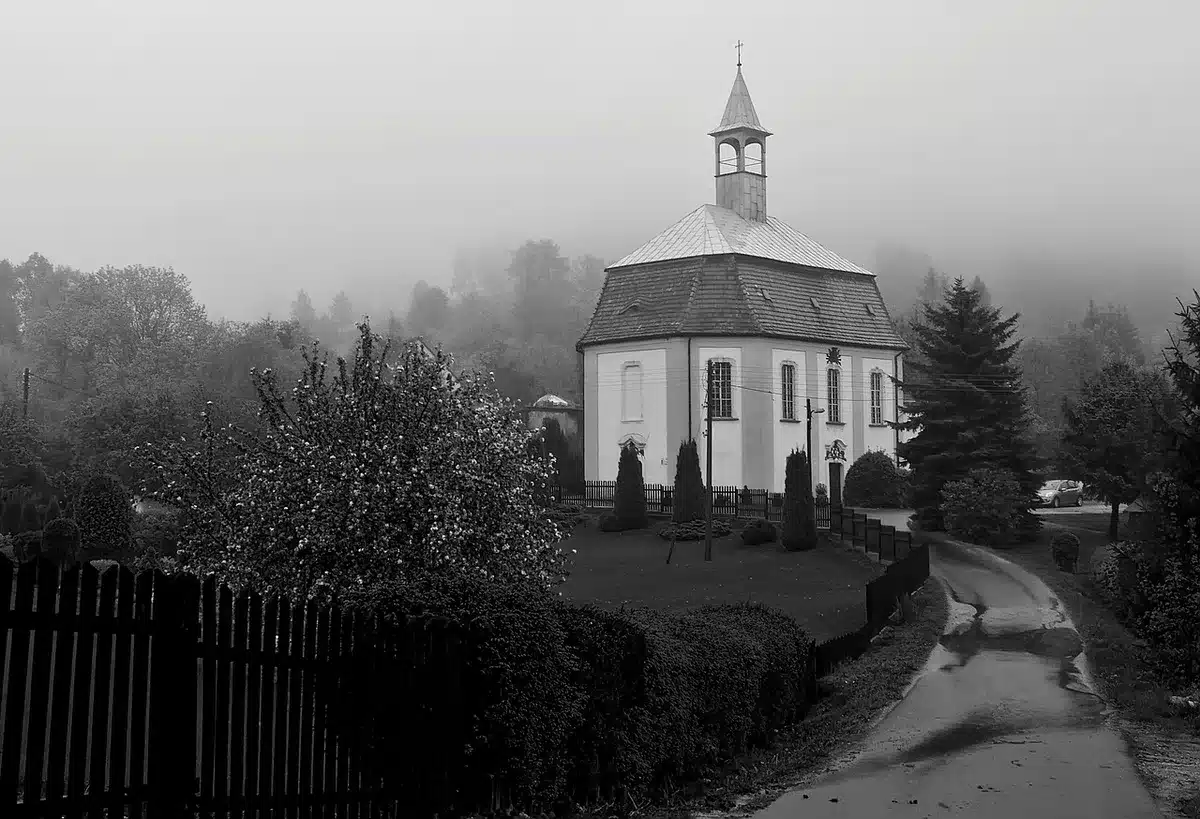 Spokojna wiejska droga w Cotswolds z domkami i żywopłotami