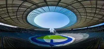 Zarys trenerów i notatnik na bocznej linii stadionu, anonimowi zawodnicy w tle